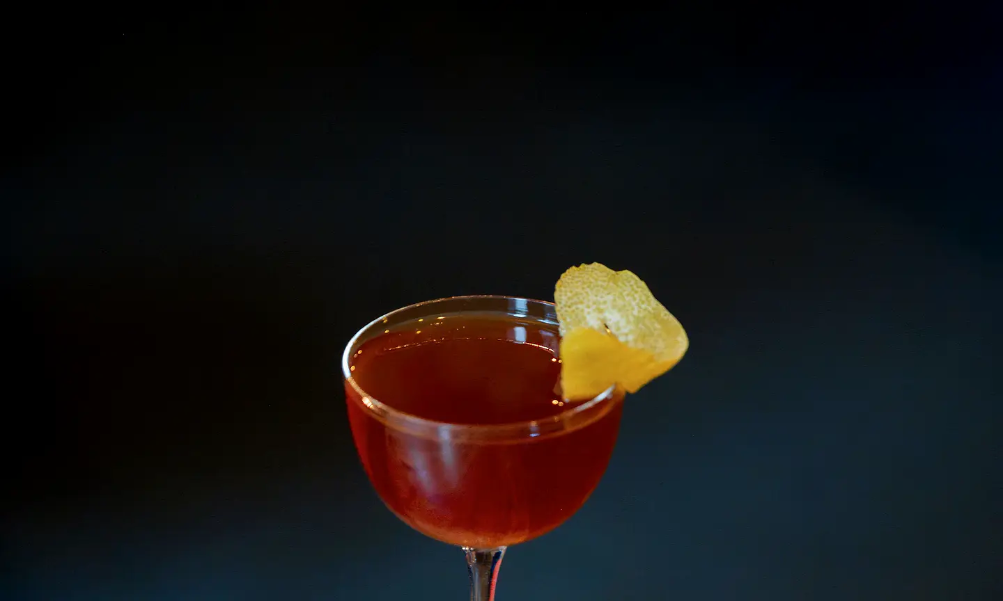Red-orange aperitivo-style drink with citrus peel.