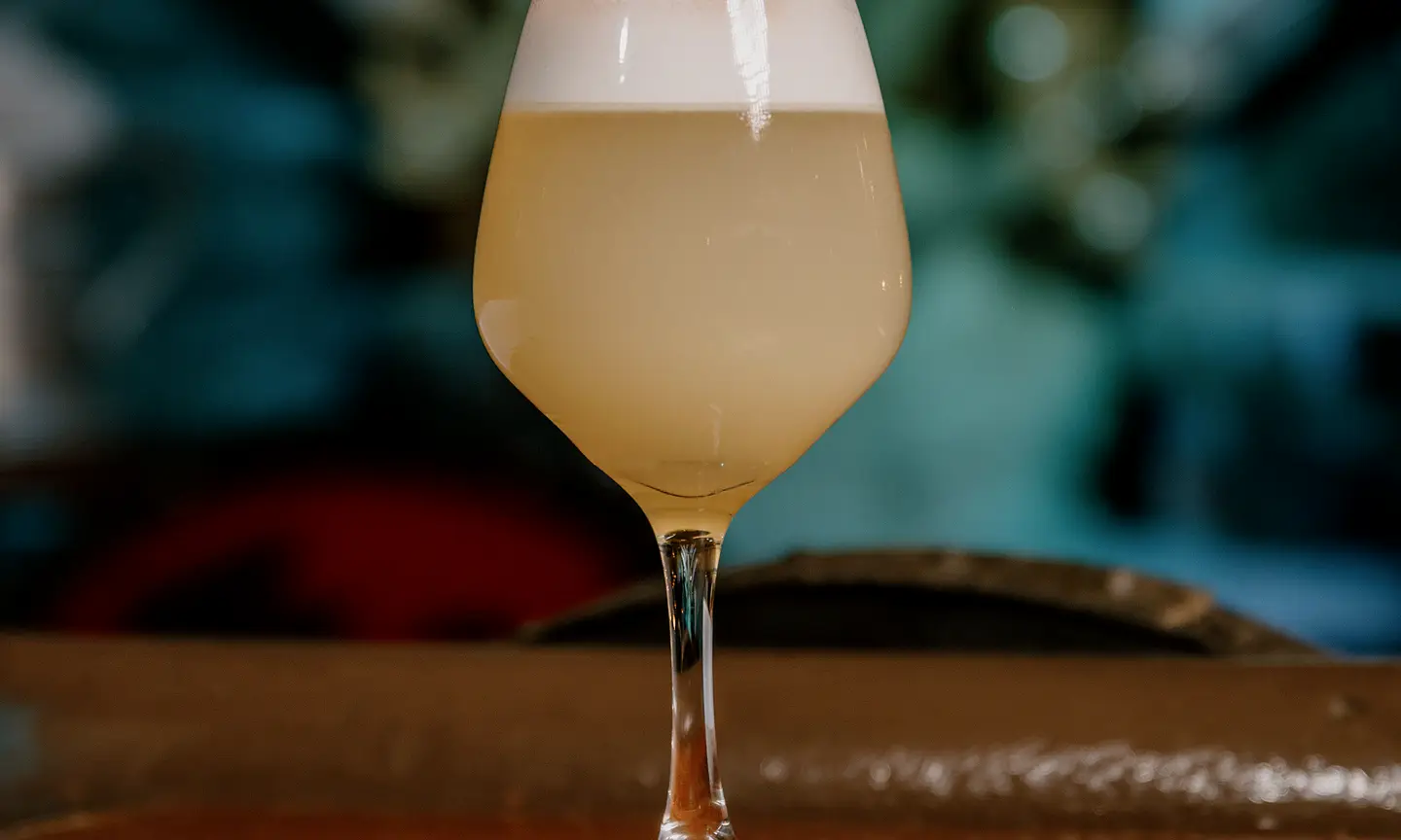 Pale-gold cocktail with lime in warm evening light.