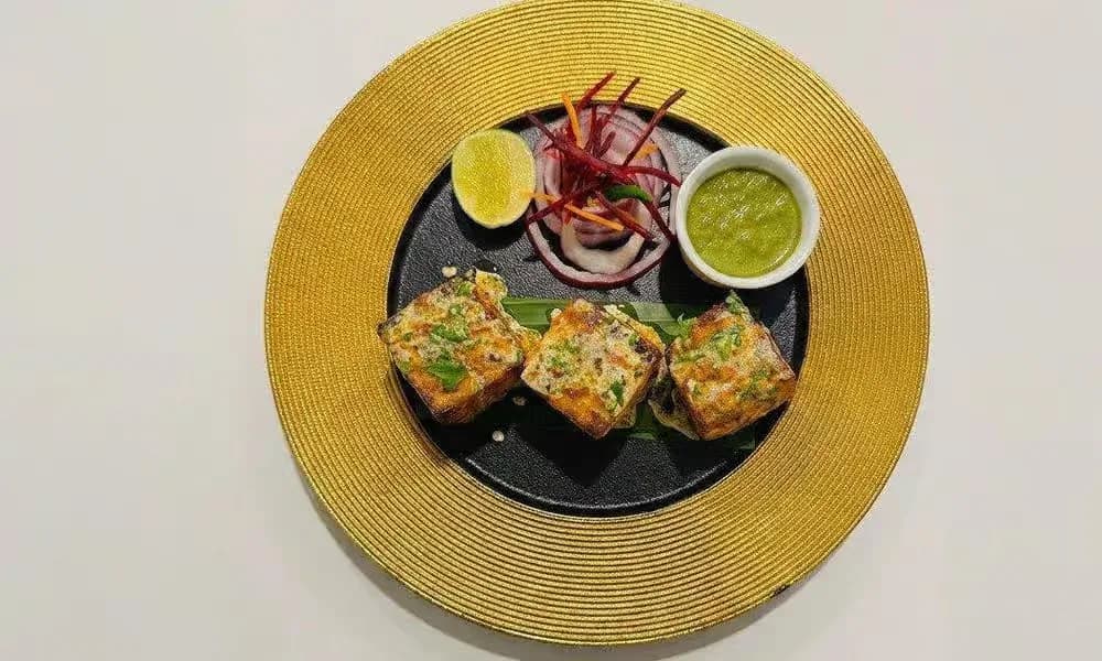 Bharwan Paneer Tikka served with onion, lemon, and green chutney.