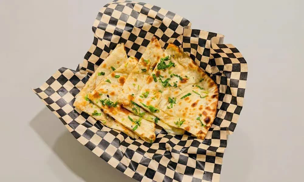Cheese Naan in a lined bread basket.