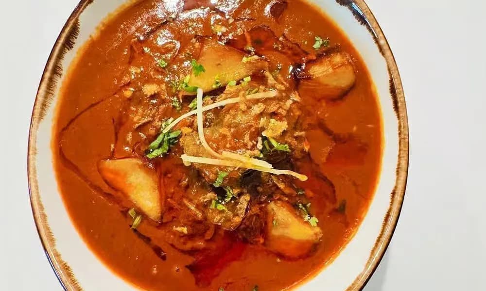 Chicken Vindaloo served in a rustic ceramic bowl.