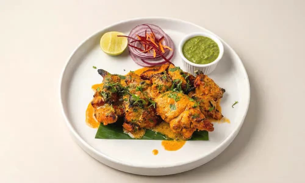 Classic Chicken Tikka served with onion, lemon, and green chutney.