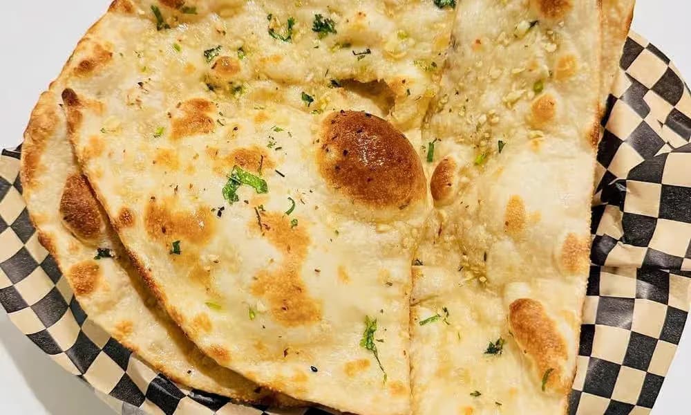 Garlic Naan in a lined bread basket.