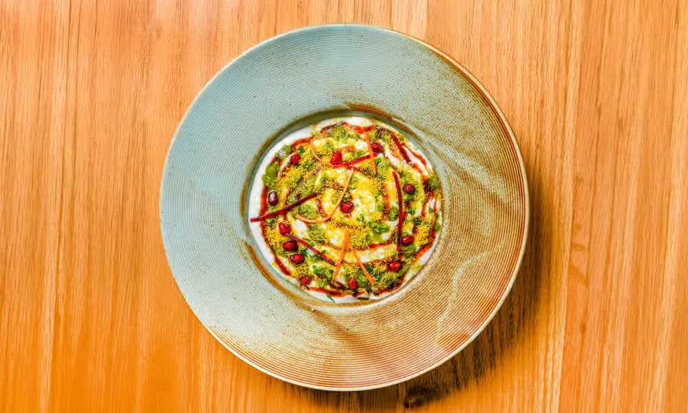 Samosa Chaat served in a shallow ceramic bowl.