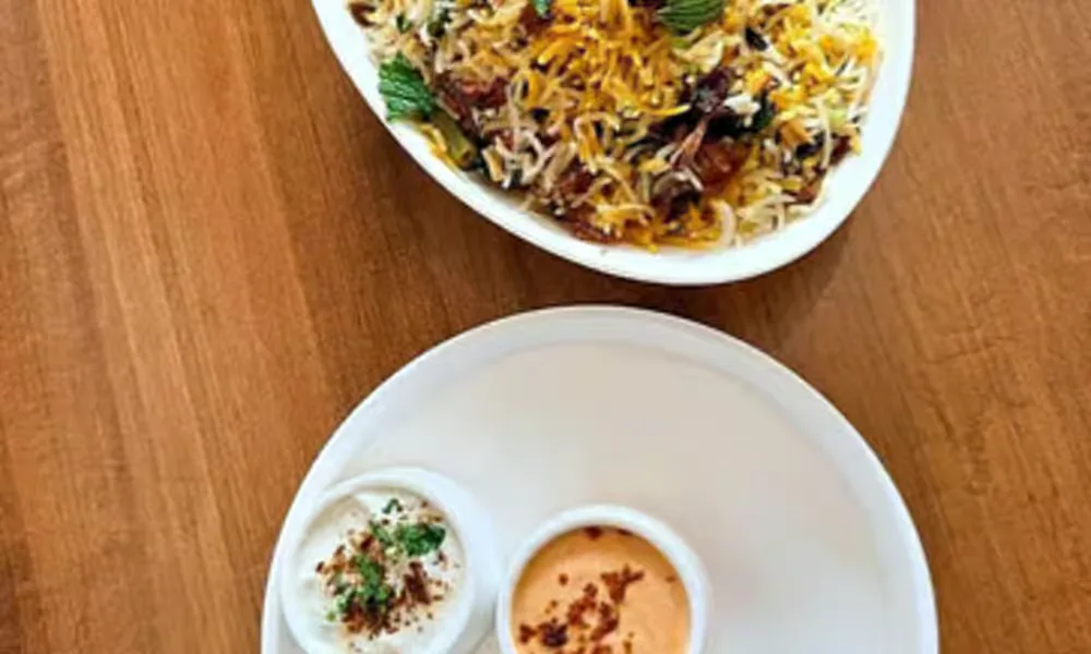 Veg Dum Biryani served with raita.