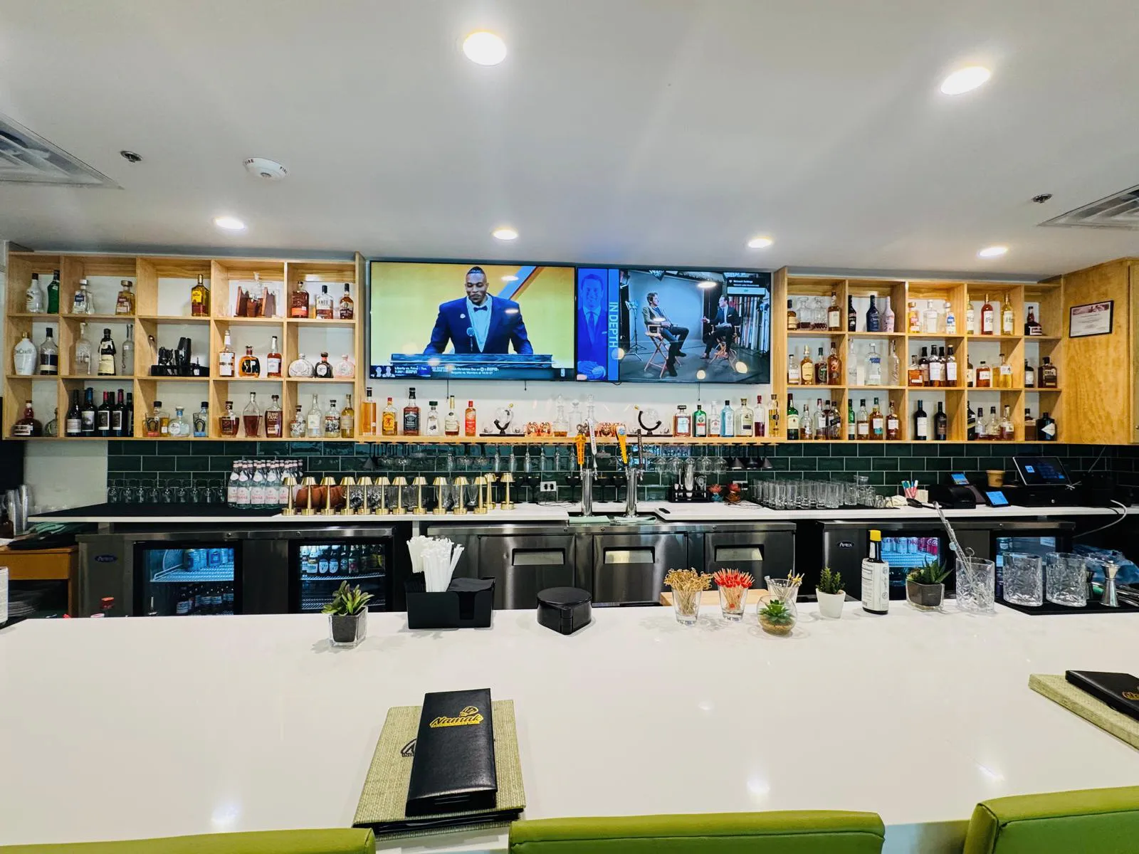 Full Namak bar with back shelving, draft taps, glassware, and a pale stone counter.