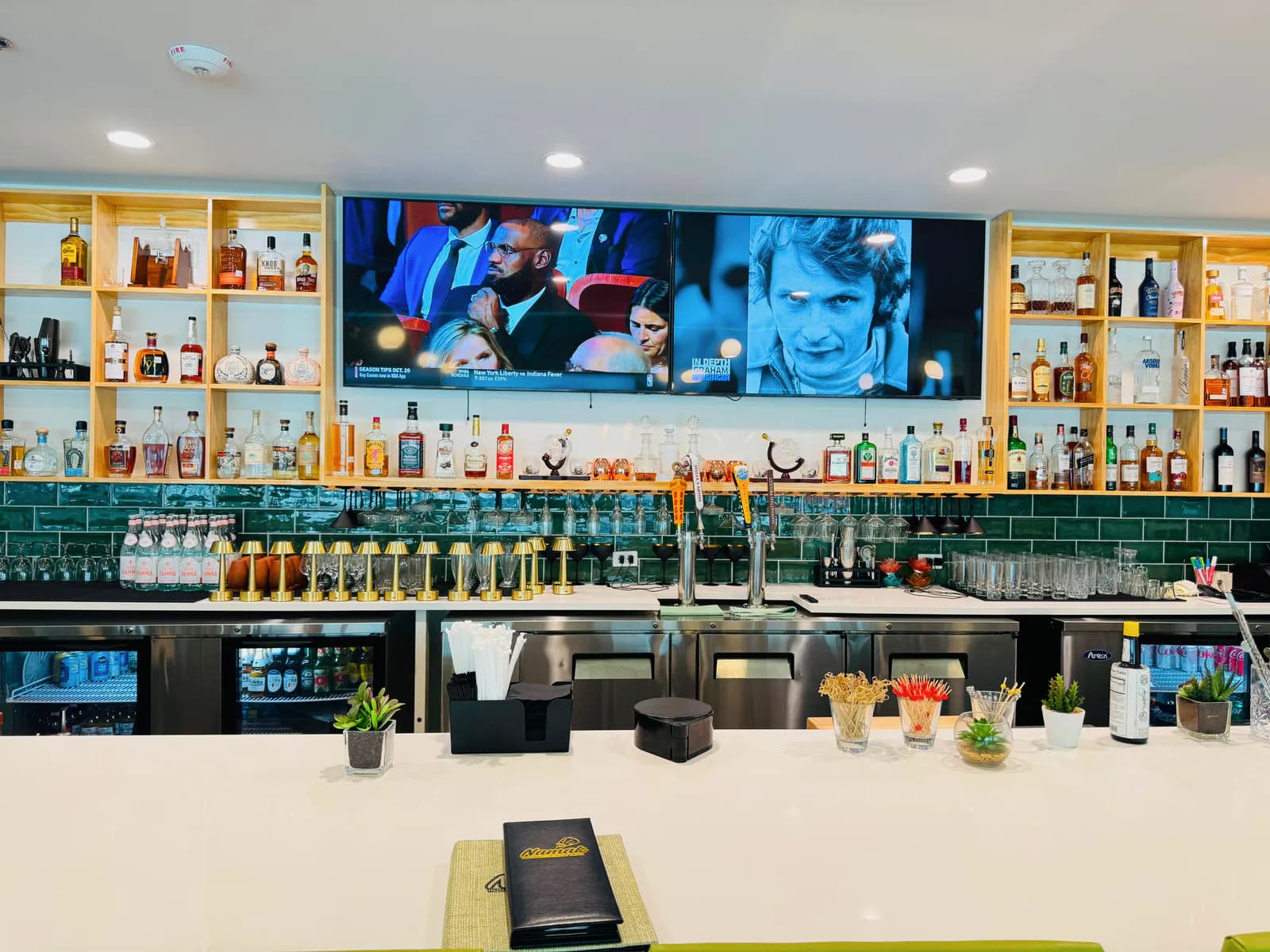 Front view of the Namak bar with draft taps, bottle shelving, and a pale counter.