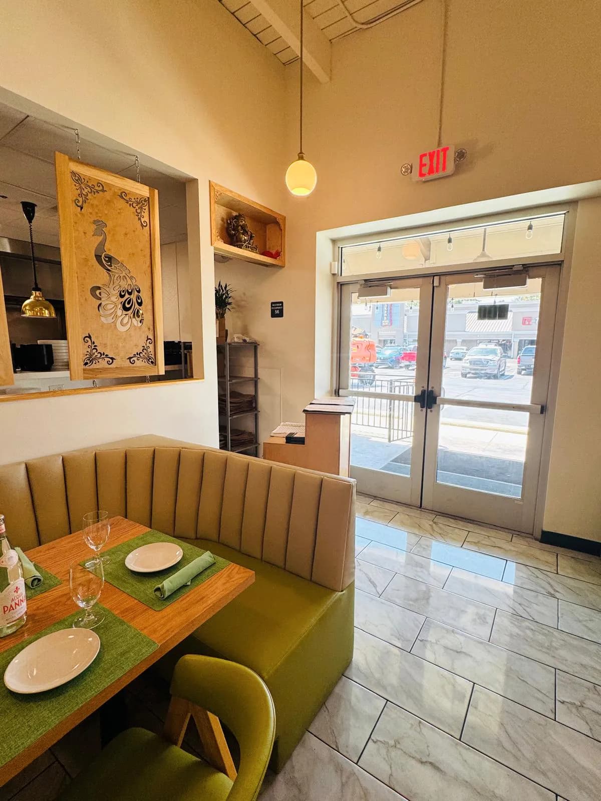 Interior view of the Namak entrance beside a curved booth and set table.